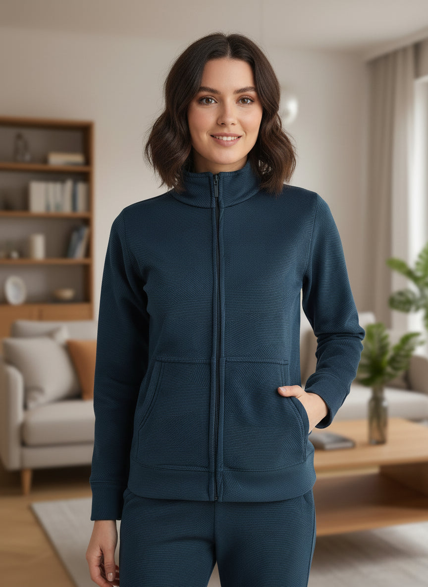 Woman wearing a teal tracksuit in a living room setting