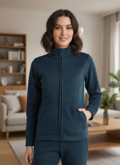 Woman wearing a teal tracksuit in a living room setting