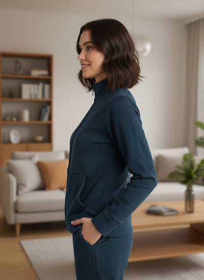 Woman in a teal outfit standing in a living room.